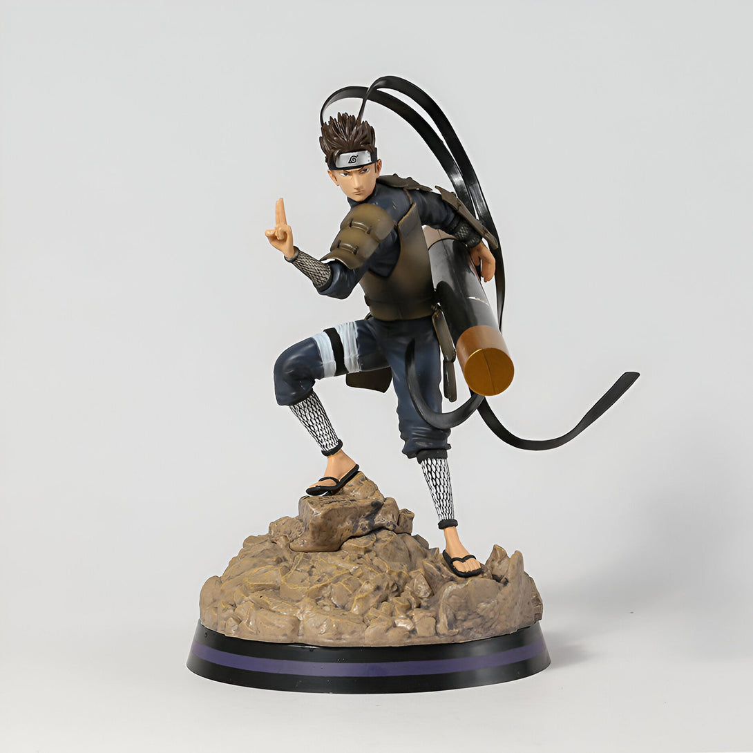 Figurine de personnage de Naruto en action, portant une armure de ninja et brandissant une arme. Il est debout sur une base rocheuse avec une pose dynamique.