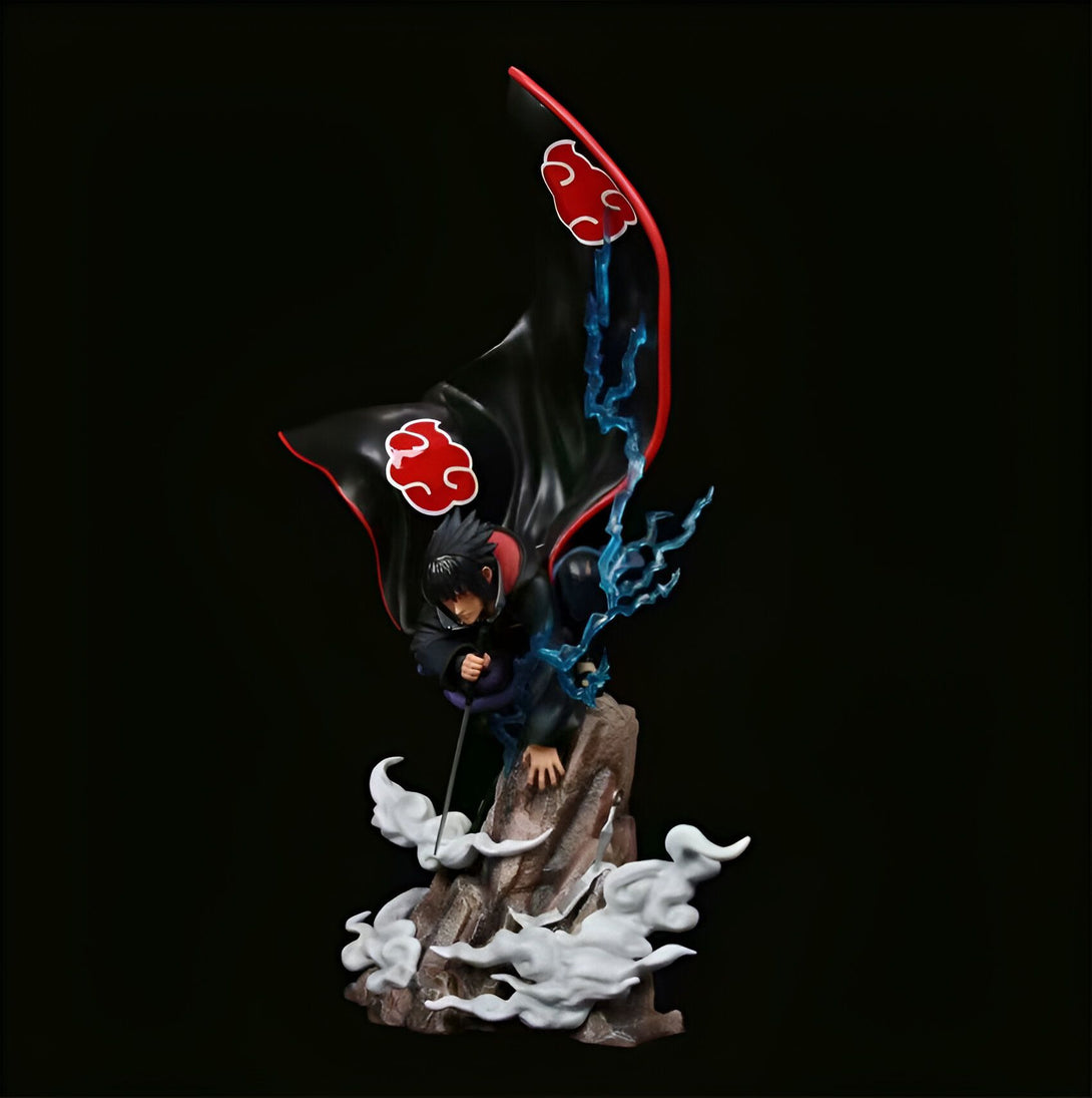 Statue de Sasuke Uchiwa en mode Rinnegan, avec un manteau rouge et noir orné du symbole de l'Akatsuki, se tenant sur un rocher entouré de nuages.