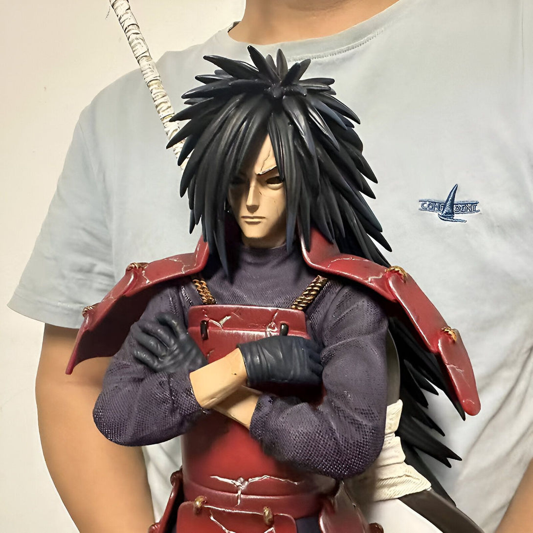Statue de Madara Uchiwa de Naruto Shippuden, vêtu de son armure rouge et tenant une épée. La statue est faite avec des détails réalistes.