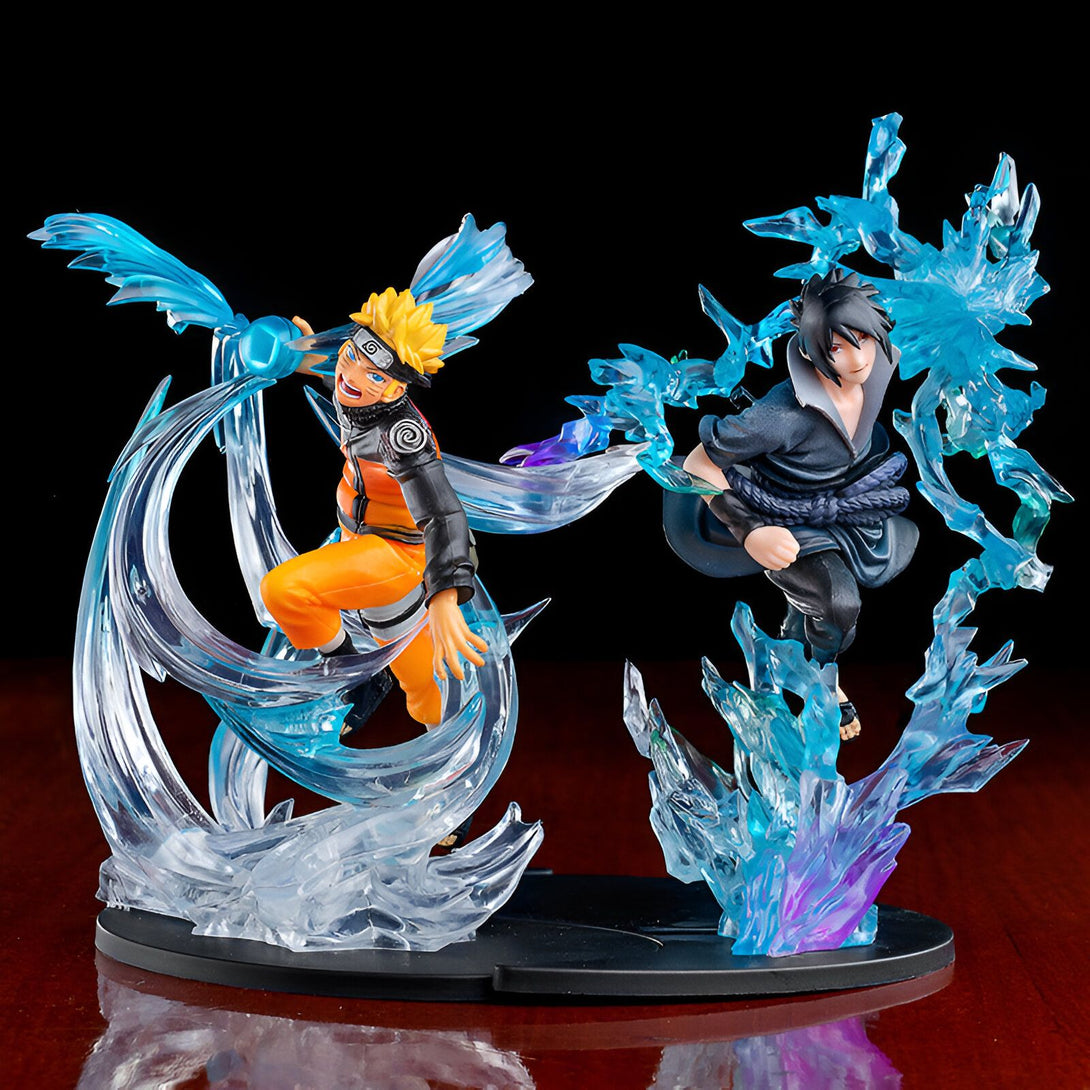 Statue de Naruto et Sasuke en action, entourés d'effets spéciaux de combat en bleu.