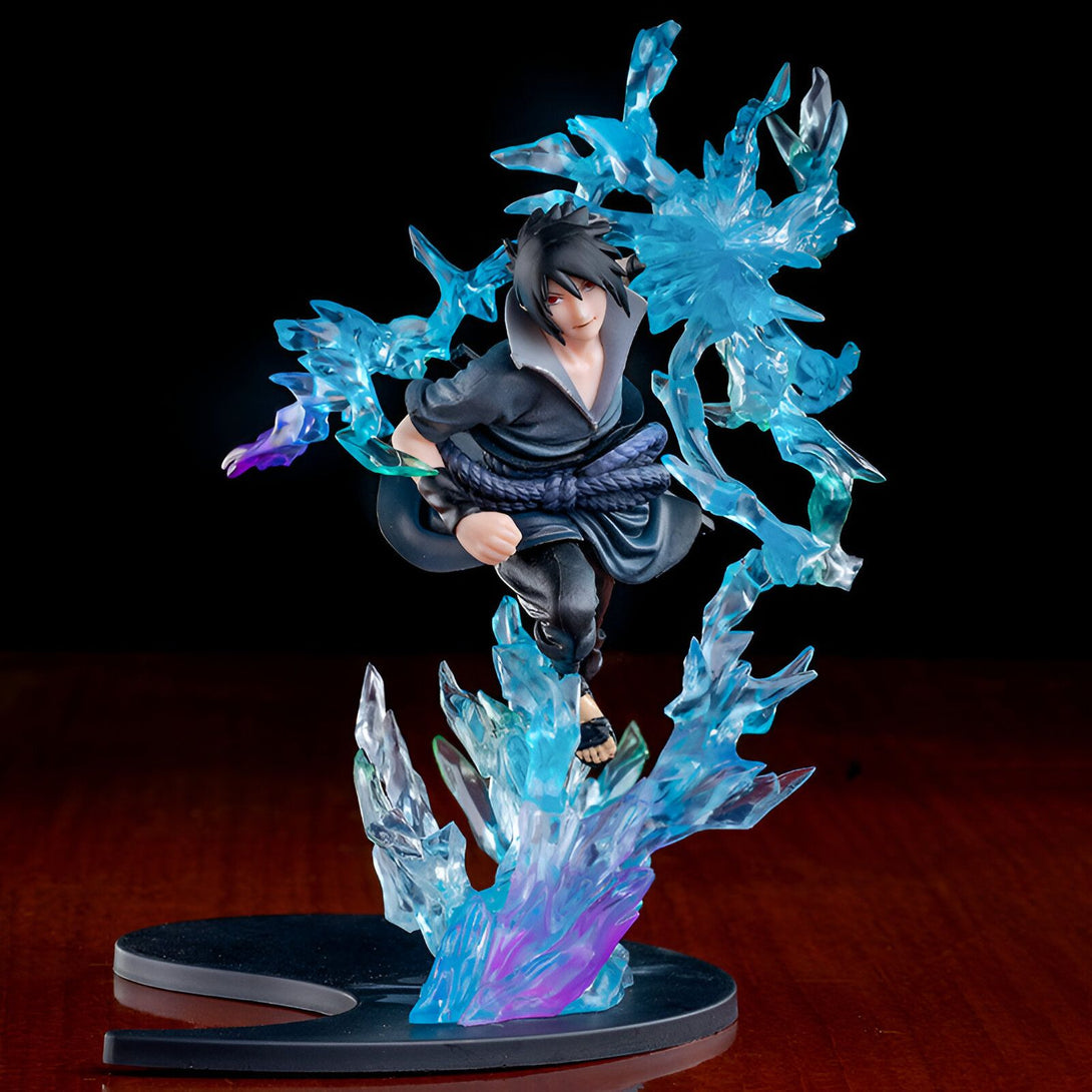 Sasuke Uchiha, un personnage du manga Naruto, représenté en figurine avec un effet de glace bleue. La figurine est posée sur un socle noir avec un motif Yin Yang.