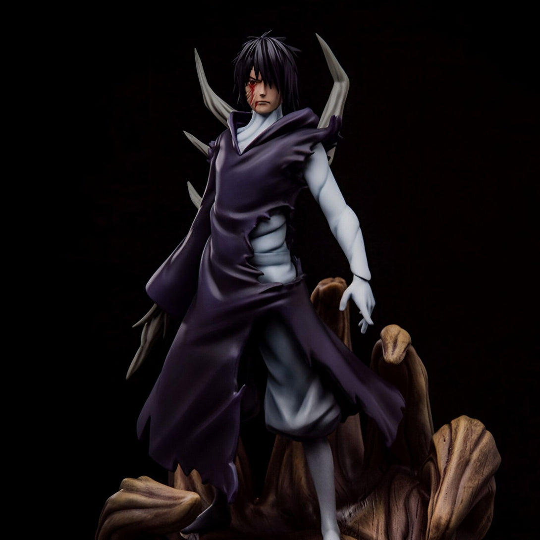 Figure de collection de Madara Uchiwa, un personnage de l'univers Naruto, dans sa forme Rikudô Sennin. Il est représenté avec sa robe violette déchirée, son Sharingan et les six chemins. La figure est posée sur un socle en bois qui représente le terrain de bataille.