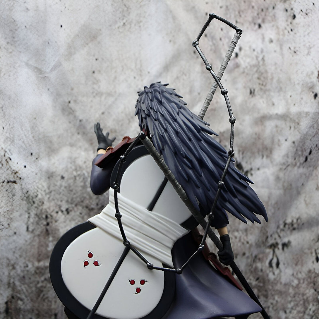 Figure de collection de Pain de Naruto Shippuden. La figurine est représentée de dos et porte son emblématique vêtement noir et sa chaîne de métal. Elle porte également son bouclier en forme de tambourin et ses trois Sharingans sur le dos.