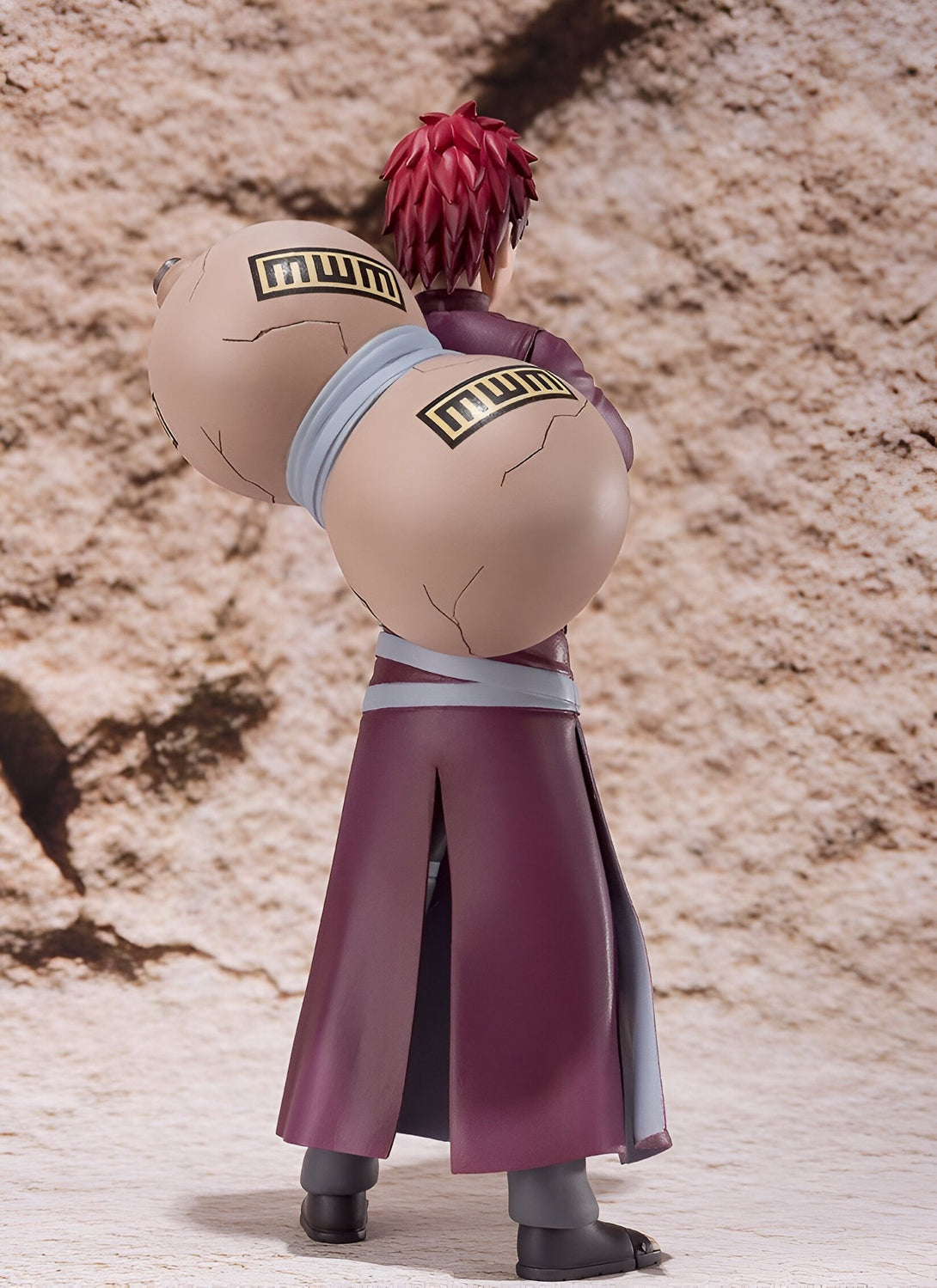 Figure de Gaara de Naruto Shippuden portant sa tenue emblématique et ses gourdins de sable, vus de dos.