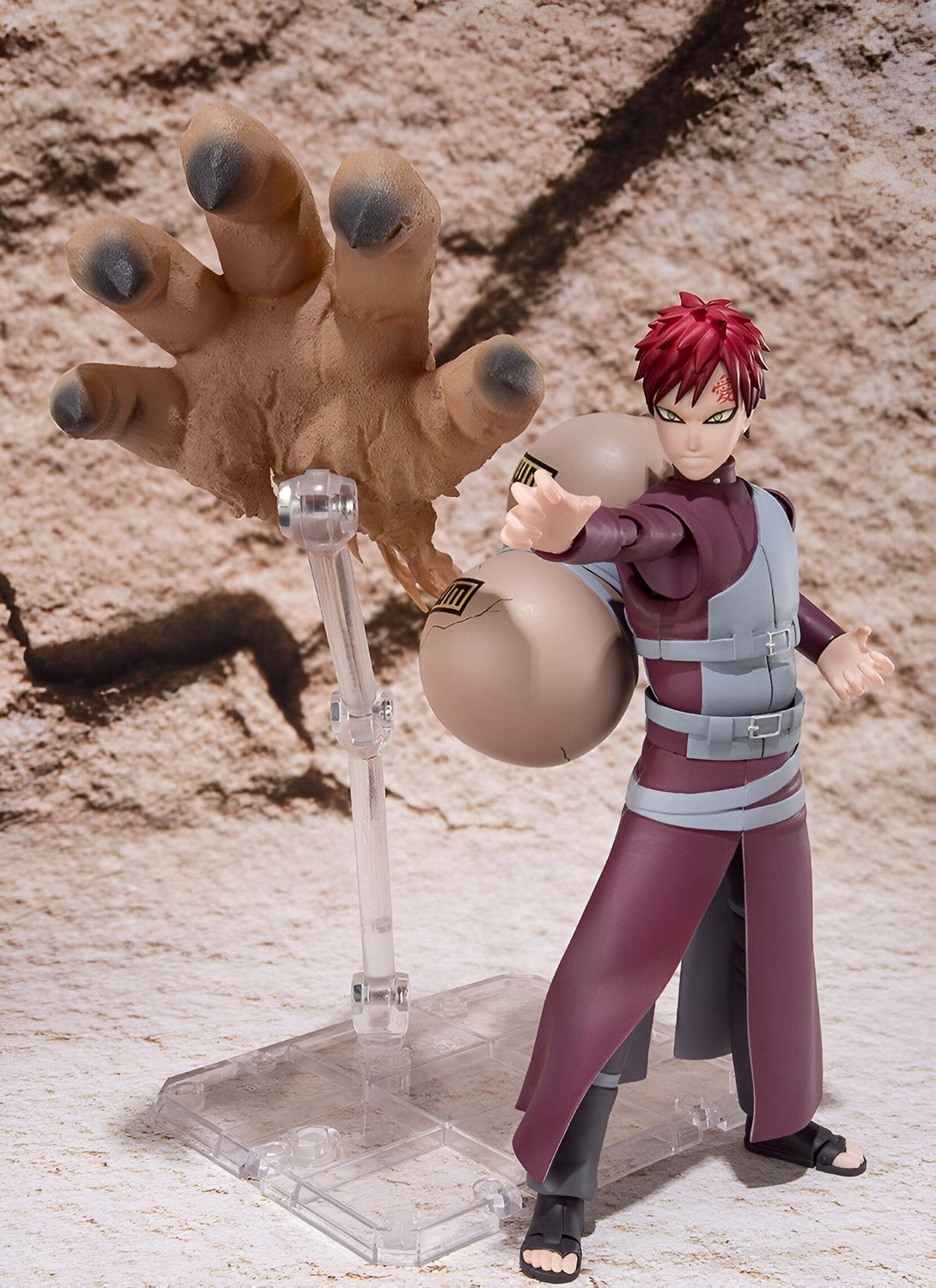 Figure articulée de Gaara de Naruto Shippuden, tenant le sablier de Shukaku avec une main géante de sable à l'arrière-plan.