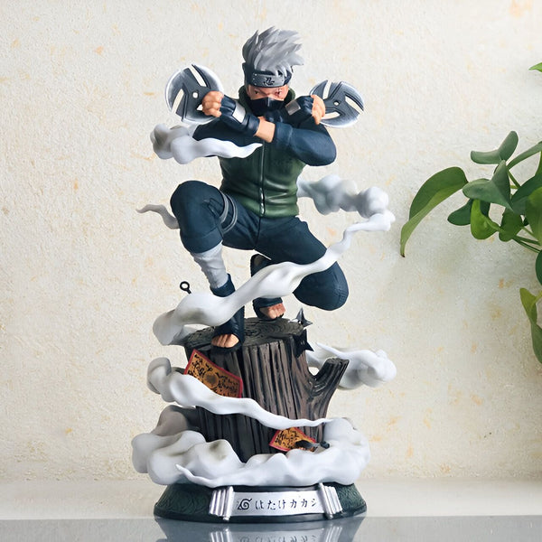 Statuette de Kakashi Hatake, un personnage du manga Naruto, posant sur une souche d'arbre avec des effets de fumée et tenant des kunaï. La figurine est en position d'attaque, prête à se battre.