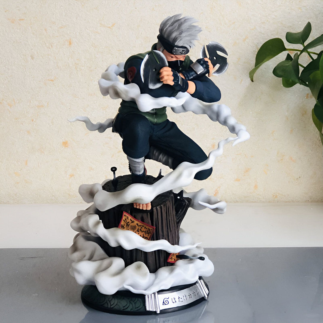 Statue de Kakashi Hatake de Naruto en action, utilisant son Sharingan, entouré de fumée, se tenant sur un tronc d'arbre avec une base décorée de symboles du manga.