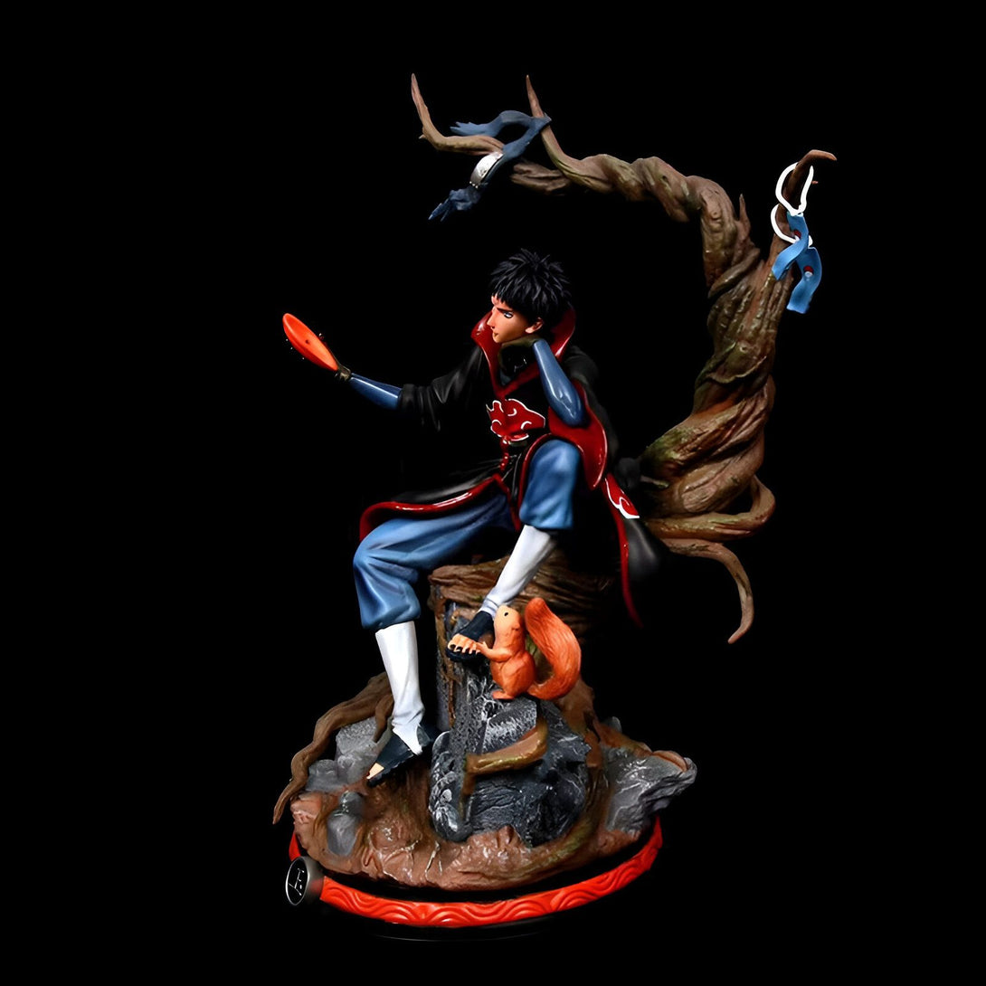 Statue de Pain, personnage de l'anime Naruto, assis sur une souche d'arbre avec un écureuil à ses pieds. Il porte sa tenue rouge et noire caractéristique et tient une gourde dans sa main.