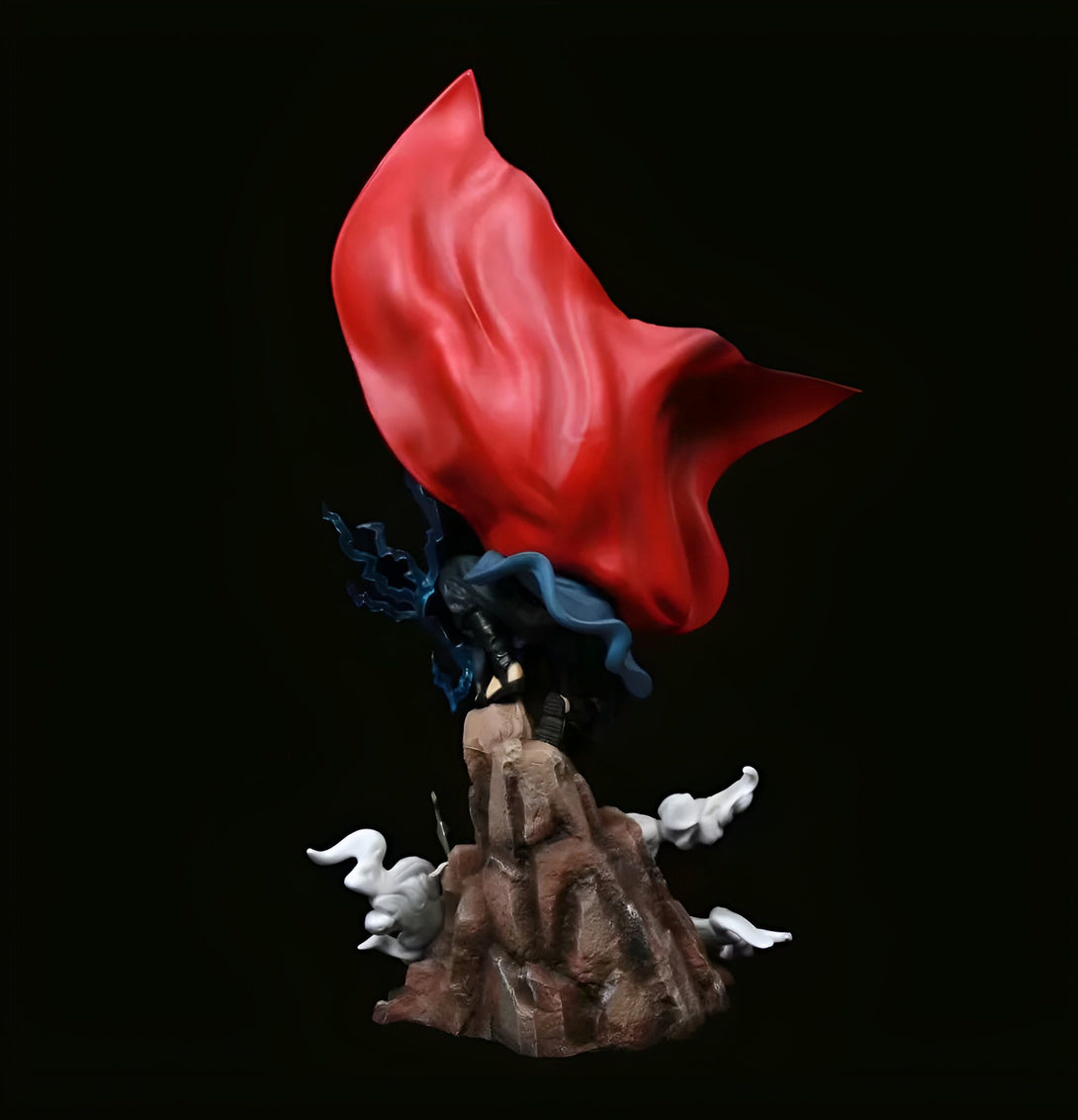 Statue de Naruto en position d'attaque, portant son célèbre manteau rouge. La figurine est posée sur un rocher avec des effets de fumée.