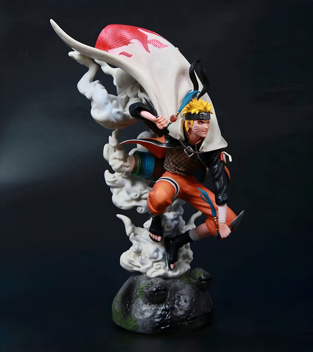 Naruto Uzumaki, le célèbre ninja de Konoha, dans une pose dynamique, vêtu de son emblématique tenue orange et portant le manteau du septième Hokage. La figurine est posée sur un socle rocheux avec des effets de fumée.