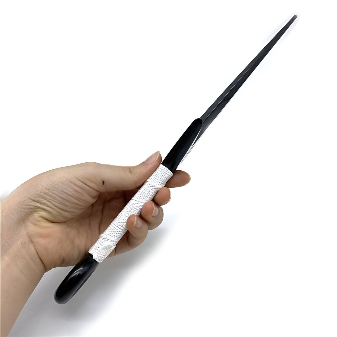Une main tenant une épée noire avec une poignée blanche. L'épée est un accessoire Naruto.