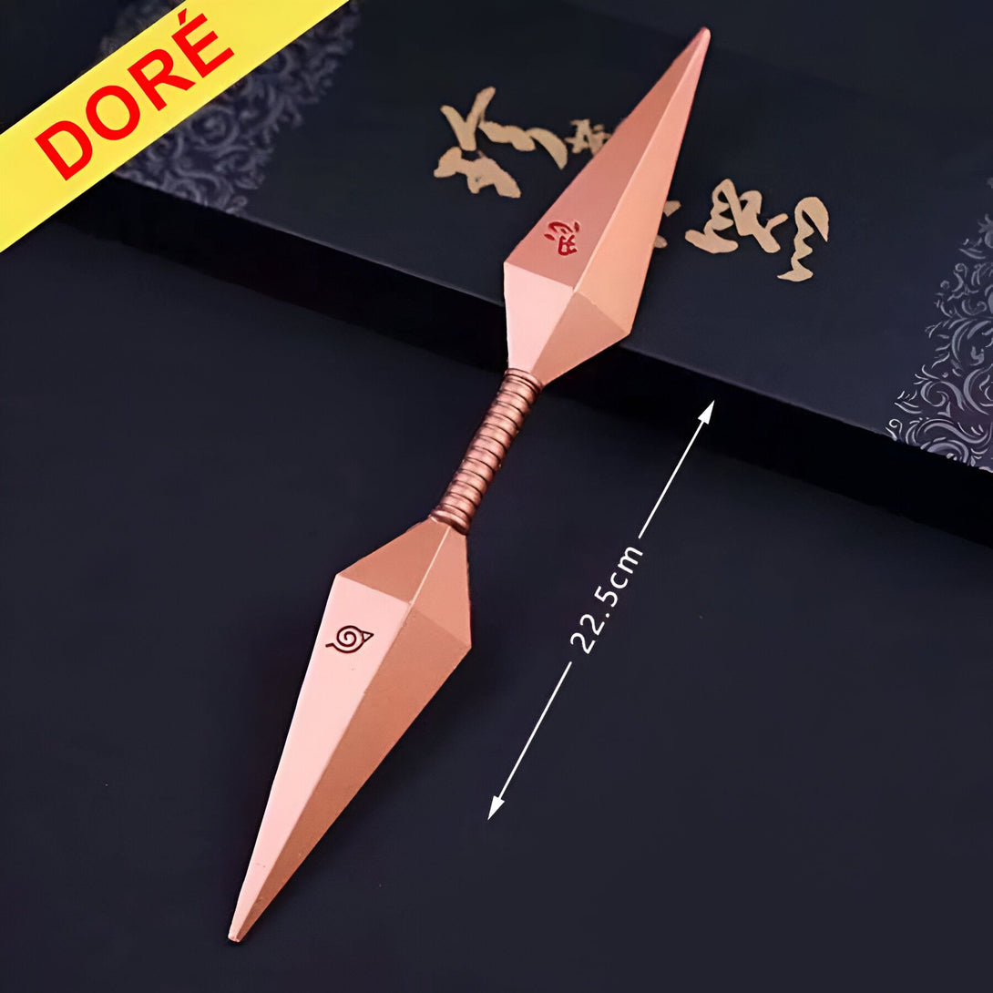 Deux kunais dorés de Naruto, armes de jet traditionnelles japonaises, posés sur un fond noir. Les kunais mesurent 22,5 cm de long et sont ornés du symbole du village caché de Konoha.