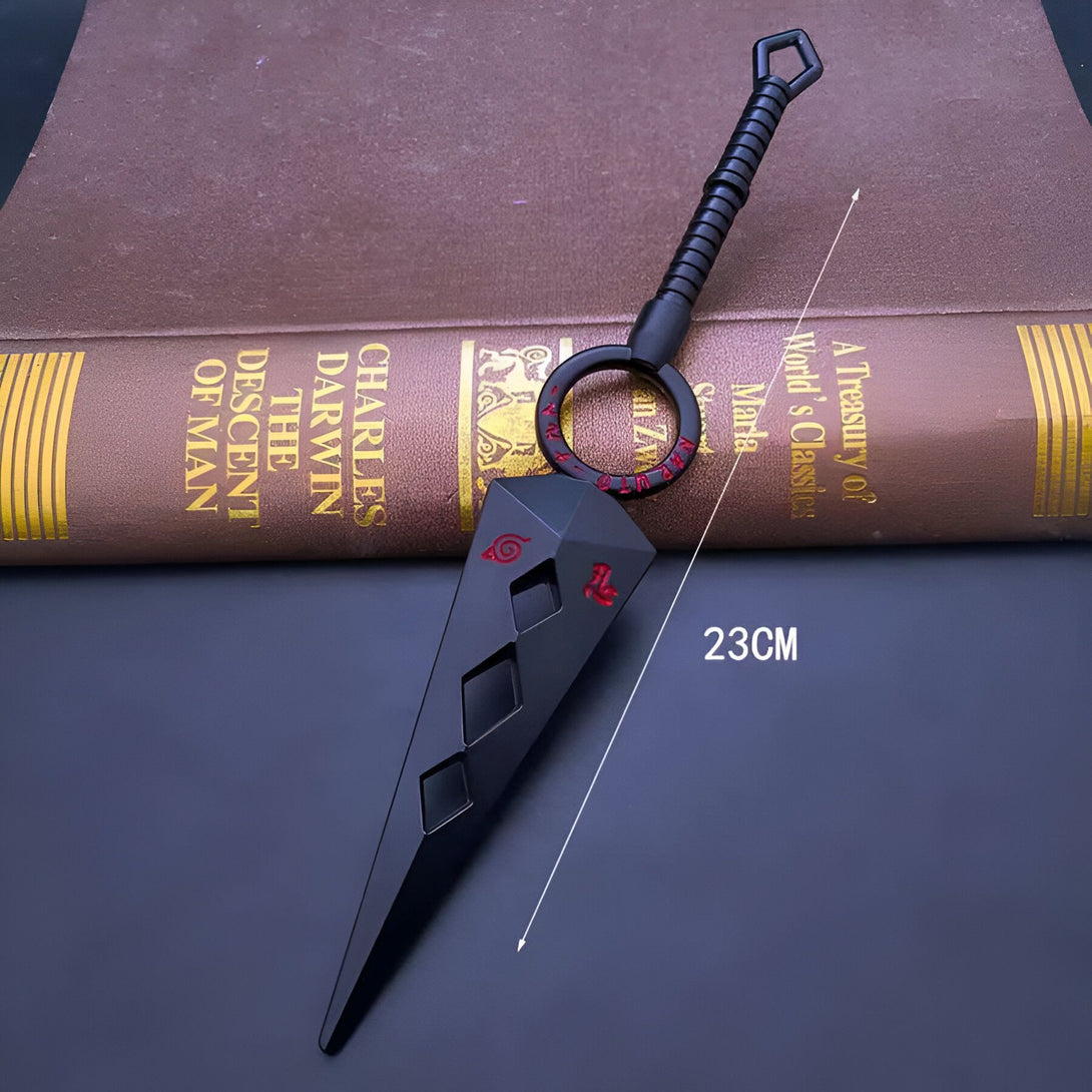 Porte-clés en forme de kunai noir avec le symbole de l'organisation Akatsuki en rouge, mesurant 23 cm de long.