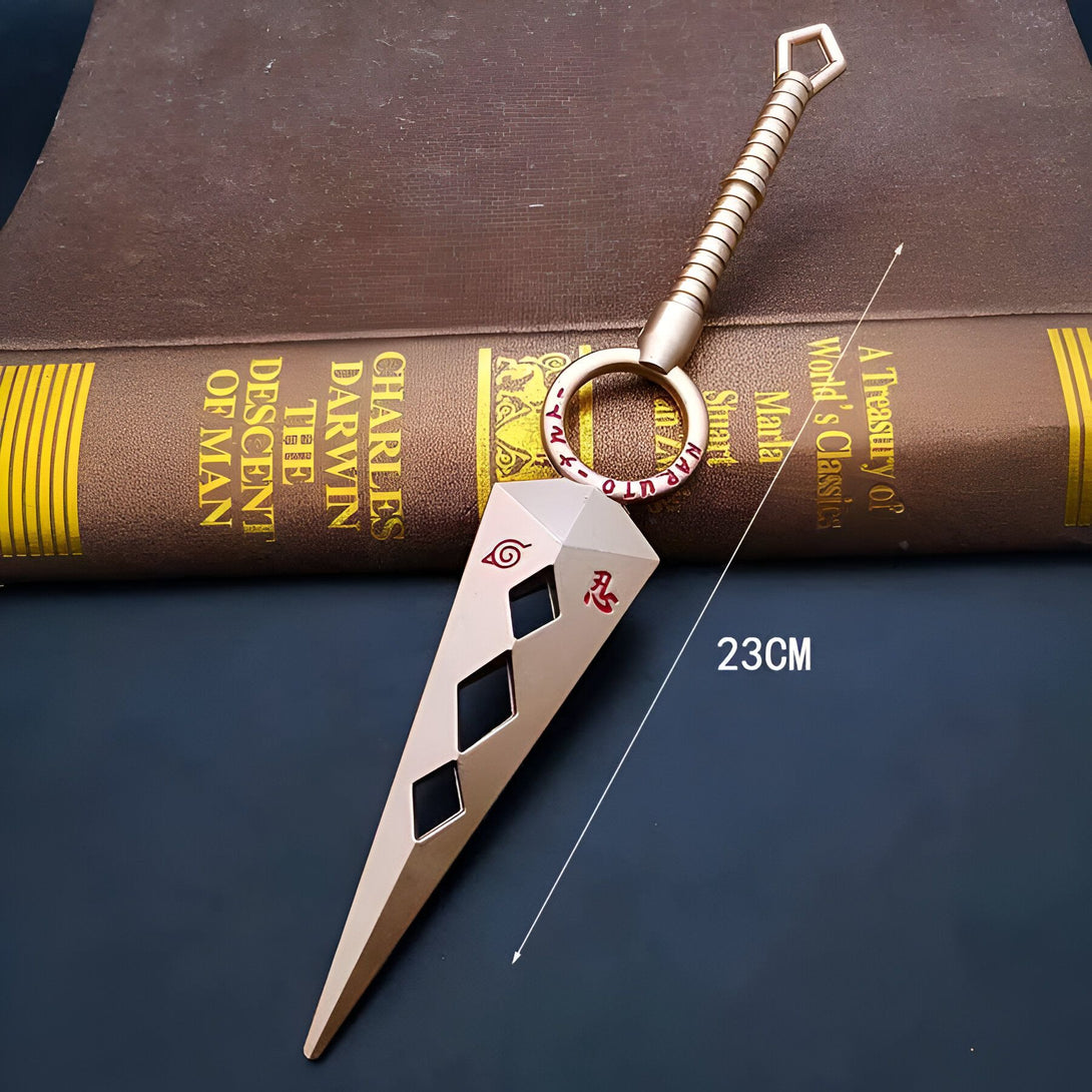 Porte-clés en forme de kunai de Naruto avec une chaîne dorée et le symbole du village caché de Konoha.  Le kunai mesure 23 cm de long.  Un accessoire parfait pour les fans de Naruto.