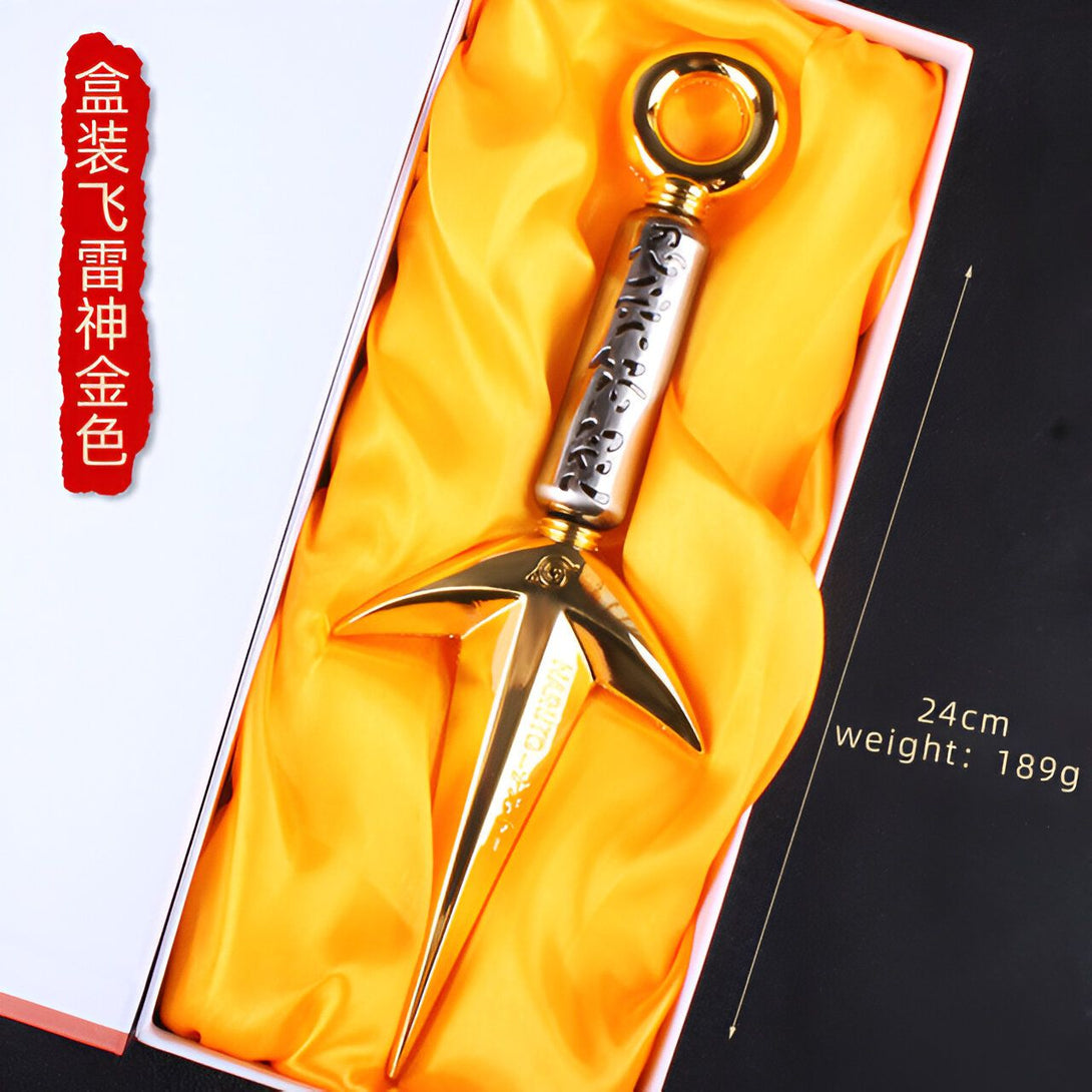 Un kunai en métal doré de Naruto dans son coffret de présentation. Il mesure 24 cm et pèse 189 grammes.  L'arme est ornée de détails gravés et un anneau en haut de la lame.