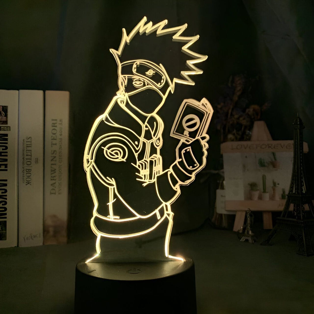 Lampe 3D de Kakashi Hatake, personnage du manga Naruto, tenant un parchemin. Cette lampe est parfaite pour les fans de Naruto et ajoutera une touche de style à n'importe quelle pièce.