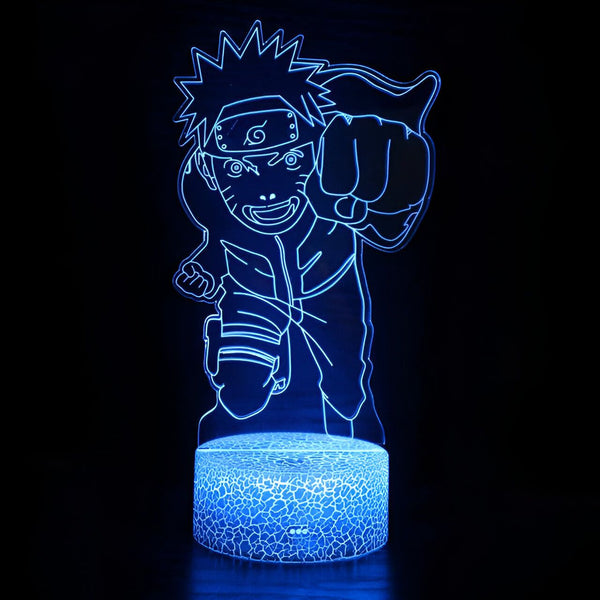 Lampe de nuit LED avec la silhouette de Naruto Uzumaki, le célèbre personnage de l'anime japonais Naruto, dans une pose dynamique avec son poing levé. La lampe est bleue et éclaire l'image de Naruto, qui est représenté avec son bandeau frontal et ses vêtements reconnaissables.