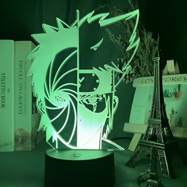 Lampe de nuit 3D représentant Obito Uchiha, un personnage de l'anime Naruto. Le design de la lampe présente le Sharingan d'Obito avec son emblématique masque. Cette lampe est un excellent cadeau pour tout fan de Naruto.