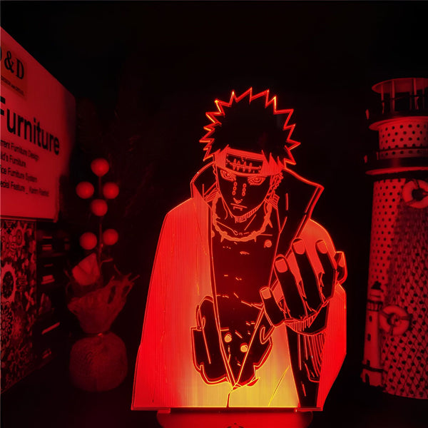 Lampe LED 3D de Pain, un personnage populaire de l'anime Naruto, dans une pose dynamique avec son style unique et ses détails reconnaissables. La lumière rouge crée une ambiance immersive. Un cadeau parfait pour les fans de Naruto.