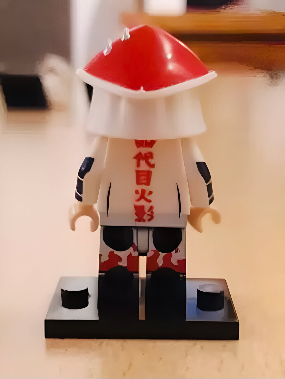 Figurines de Naruto en forme de LEGO, le personnage porte un chapeau rouge et blanc avec des caractères japonais sur son torse.