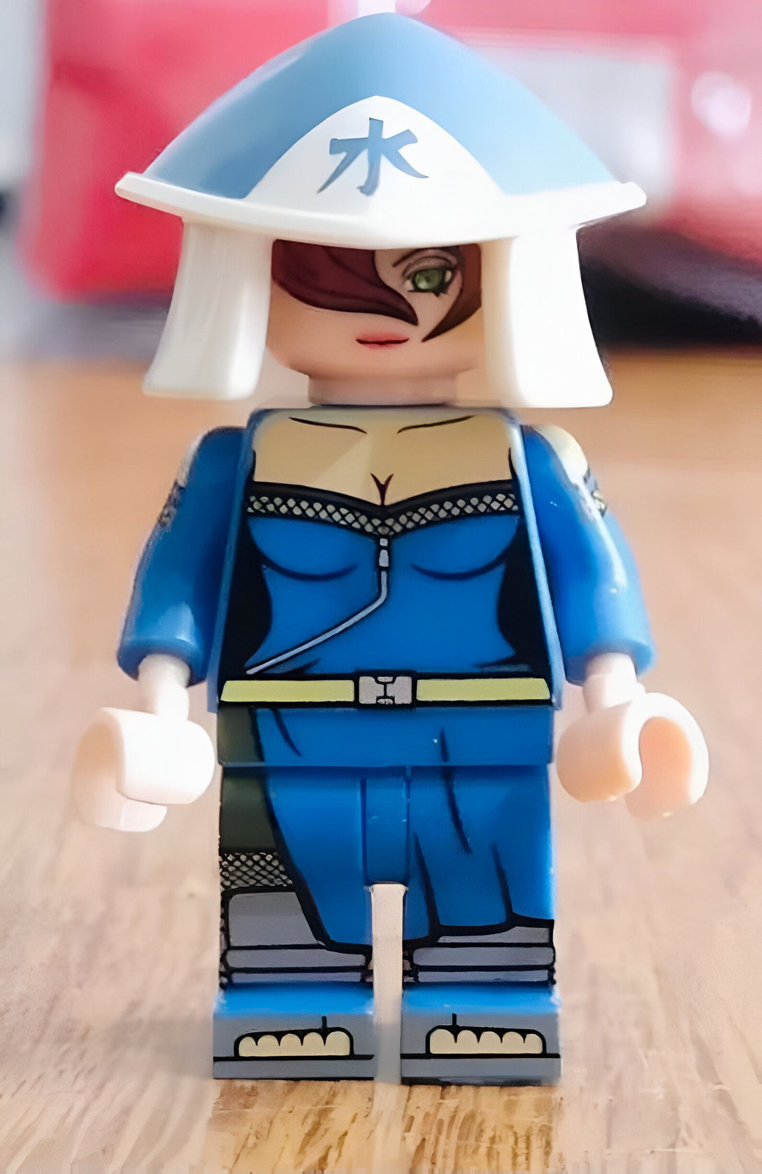 Figurines LEGO de Naruto, représentant un personnage féminin avec une tenue bleue et un chapeau blanc avec le kanji "eau" écrit dessus.
