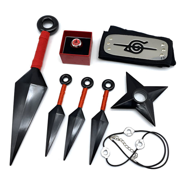 Ensemble de produits Naruto comprenant une grande lame, trois petites lames, un collier avec un pendentif, une étoile de ninja et un bandeau avec le symbole de l'Akatsuki. Le tout est présenté sur un fond blanc.