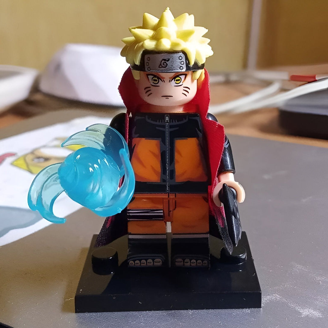 Naruto Uzumaki, le célèbre ninja de Konoha, est représenté dans une figurine LEGO. Il porte sa tenue orange iconique, son bandeau frontal et son manteau rouge. Il tient dans sa main gauche une boule d'énergie bleue, symbole de son jutsu.
