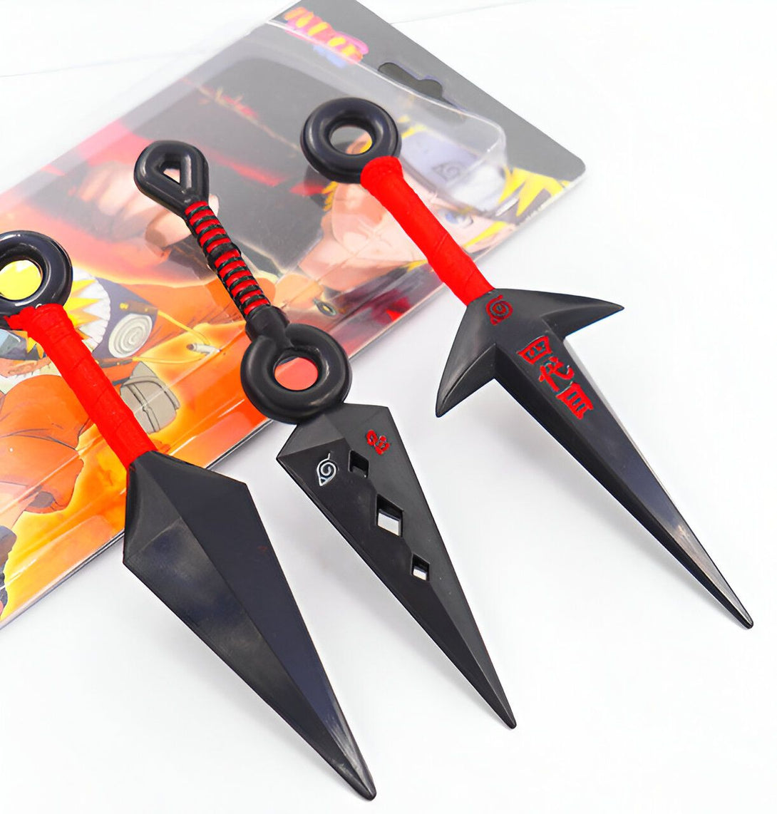 Trois kunais Naruto en plastique noir avec des poignées rouges et le symbole du village caché de Konoha. Les kunais sont des armes traditionnelles japonaises.
