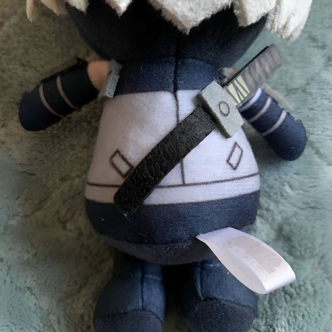Peluche de Naruto Uzumaki en tenue de ninja, portant un katana sur le dos.  La peluche est de couleur bleue et blanche avec des détails noirs.