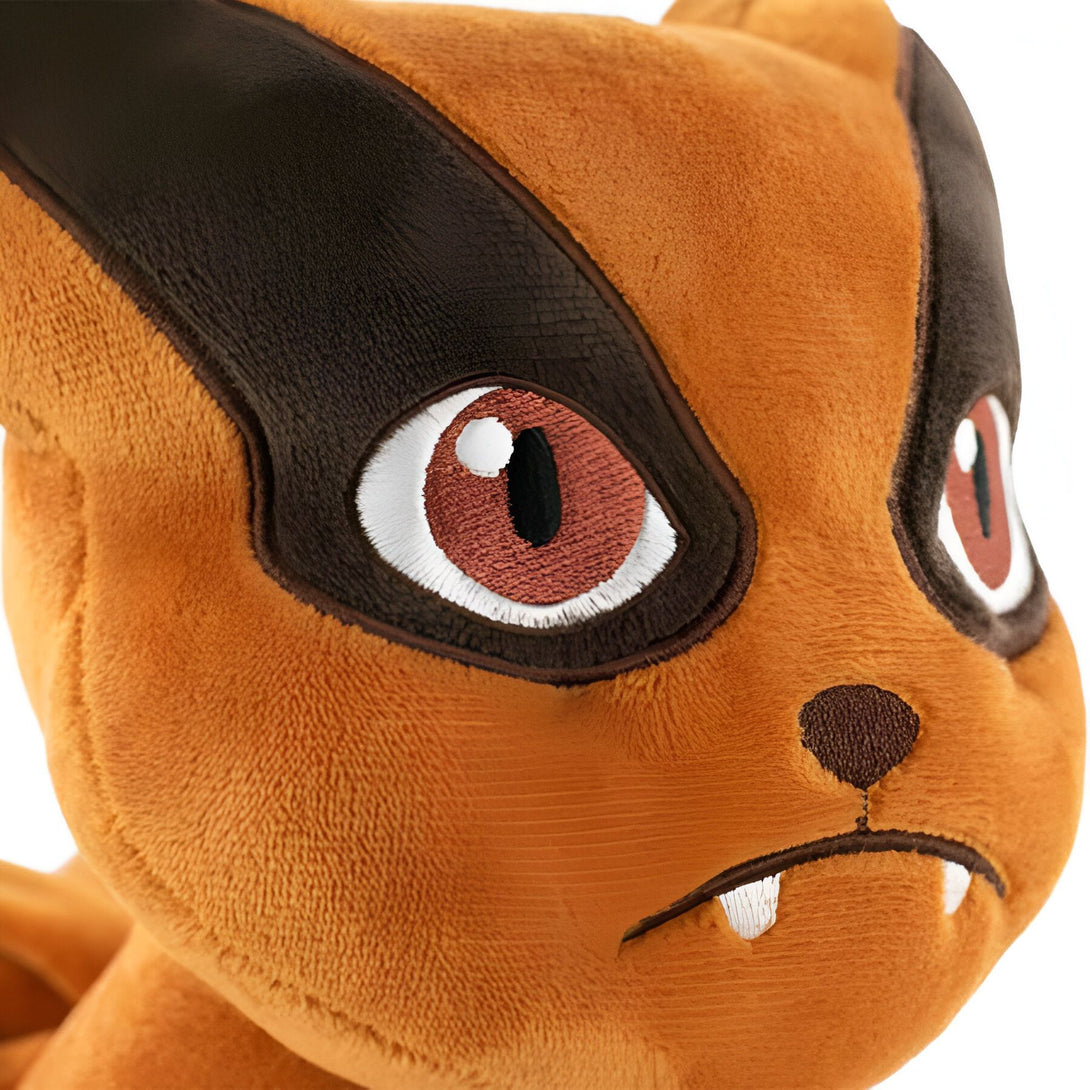 Gros plan sur la tête d'une peluche de Kurama, un personnage du manga Naruto, avec des yeux rouges et des dents pointues.