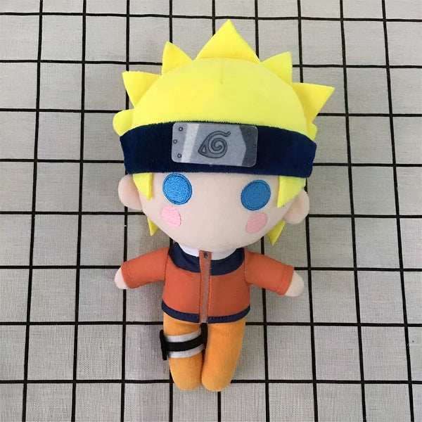 Peluche Naruto Uzumaki en position assise, portant sa tenue orange emblématique avec son bandeau frontal noir et son symbole du village de Konoha. Il a les yeux bleus et un sourire amical.