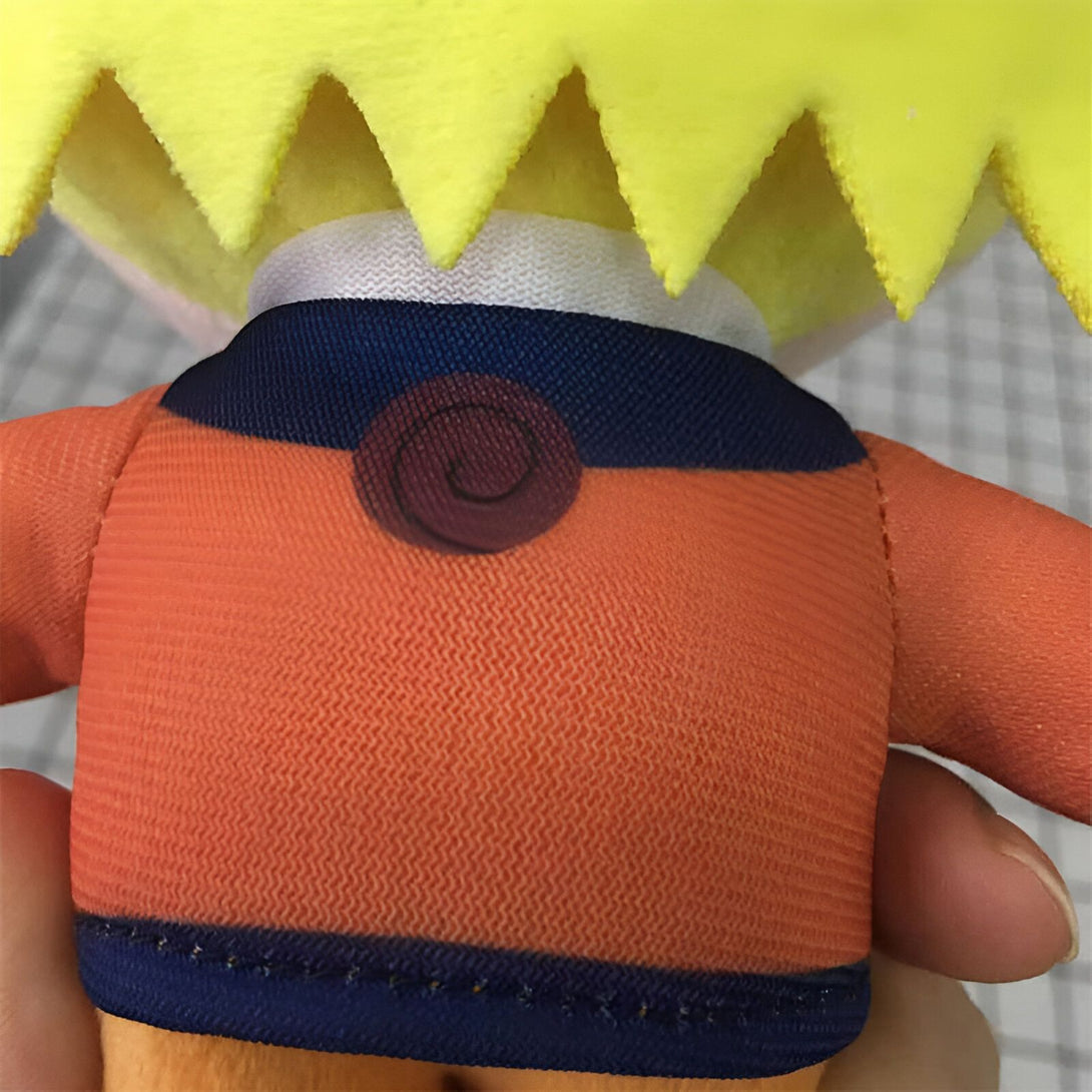 Peluche Naruto portant son costume orange emblématique avec le symbole du village de Konoha sur la poitrine.