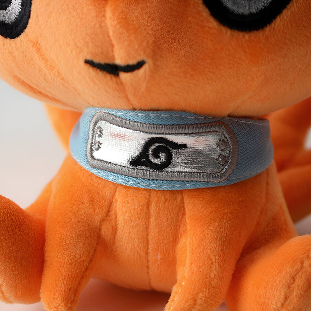 Peluche orange de Naruto avec le symbole du village de Konoha sur son cou.