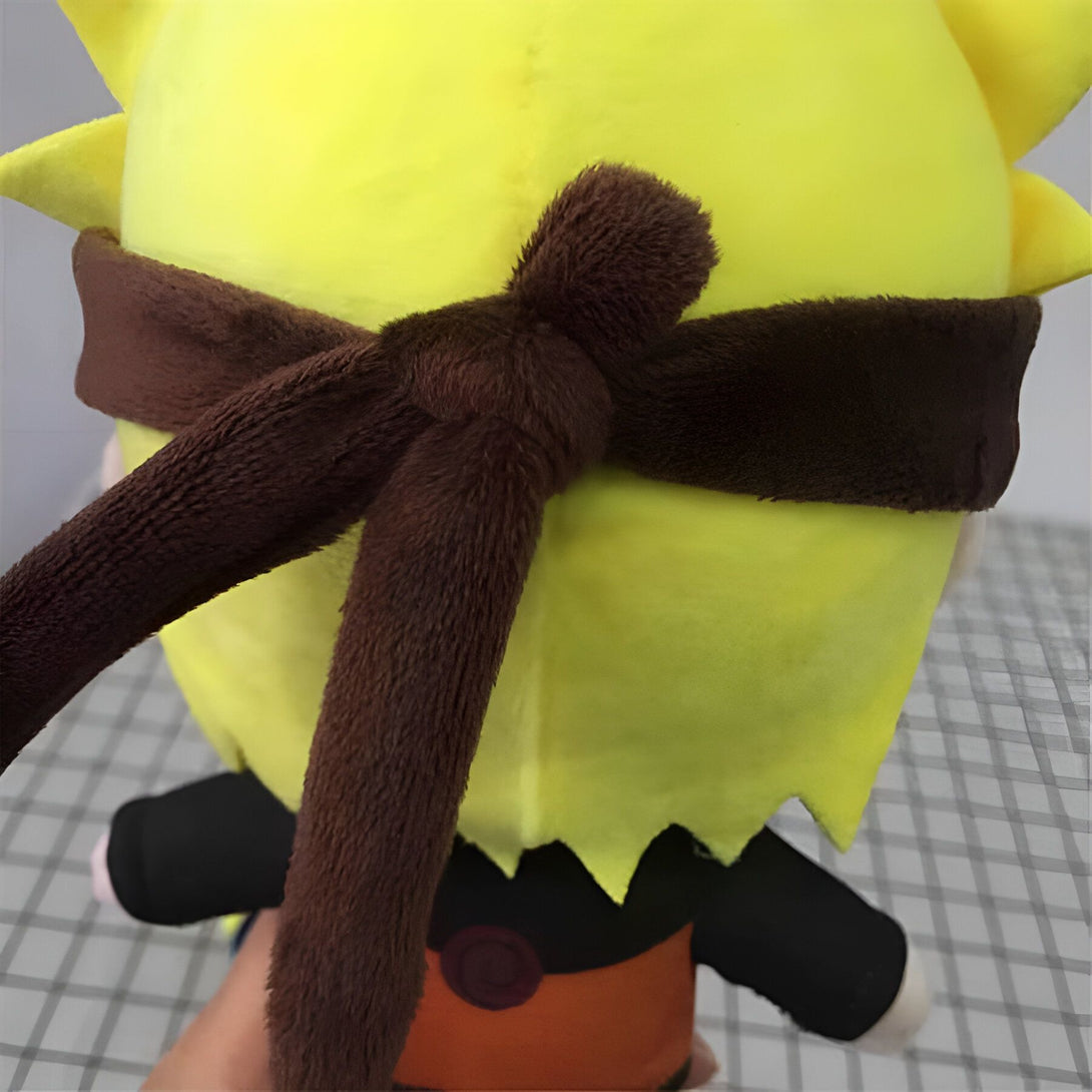 Peluche de Naruto Uzumaki avec des cheveux jaunes et un bandeau marron. La peluche est vêtue de son costume orange et noir typique.  Un excellent cadeau pour les fans de Naruto !