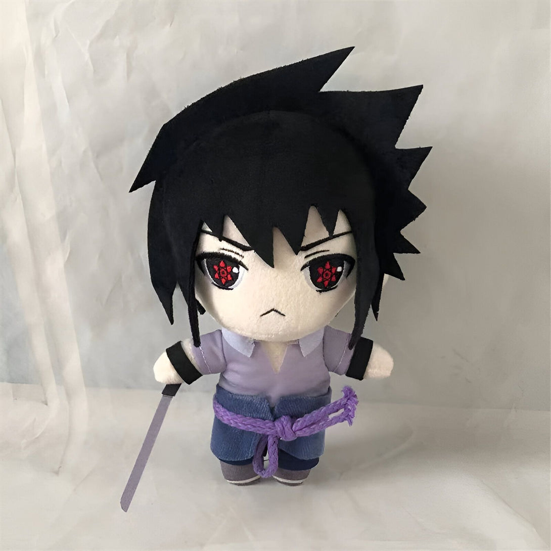 Peluche de Sasuke Uchiha de la série anime Naruto. Sasuke porte sa tenue classique de l'anime et tient son épée. Il a les yeux rouges du Sharingan.