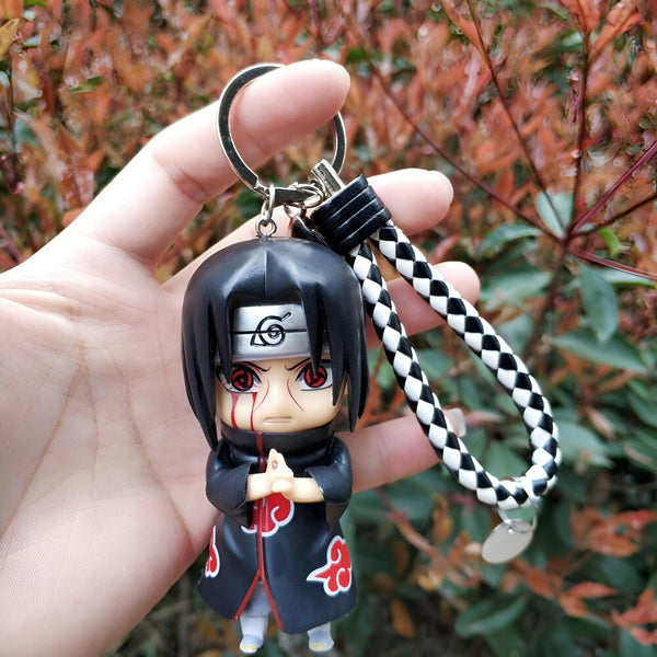 Porte-clés en forme de figurine de Itachi Uchiha de l'anime Naruto, avec un design chibi et un cordon noir et blanc.