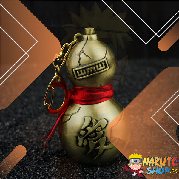 Porte-clés en forme de gourde dorée avec un ruban rouge, orné d'idéogrammes japonais et du symbole "WMUU". Un accessoire parfait pour les fans de Naruto.