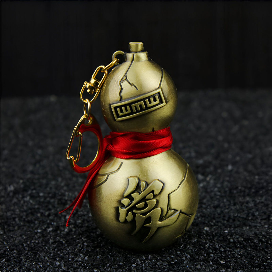 Porte-clés en forme de gourde dorée avec un ruban rouge, représentant le symbole "WMWW" et le caractère chinois "愛" (amour). Un accessoire idéal pour les fans de Naruto.