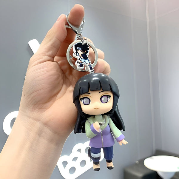Porte-clés Naruto avec une figurine de Shikamaru et une figurine de Hinata. Le porte-clés est en métal argenté avec un design chic. La figurine de Shikamaru est en plastique transparent et la figurine de Hinata est en plastique coloré. Le porte-clés est parfait pour les fans de Naruto.