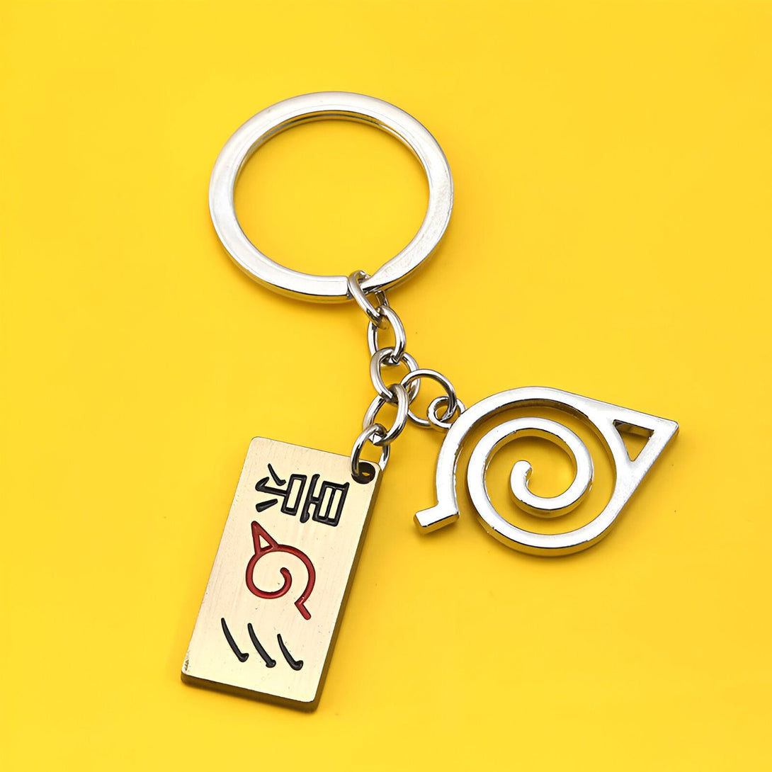 Porte-clés en métal avec le symbole du village caché de Konoha et le kanji "Konoha" en japonais.