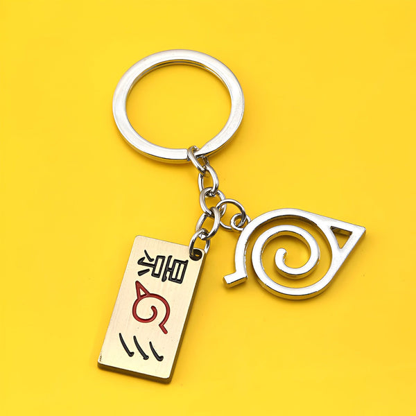 Porte-clés en métal avec le symbole du village caché de Konoha et le kanji "Konoha" en japonais.