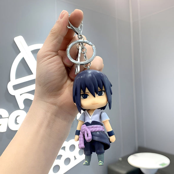 Porte-clés Naruto en forme de figurine de Sasuke Uchiha, portant sa tenue signature avec un bandana violet.