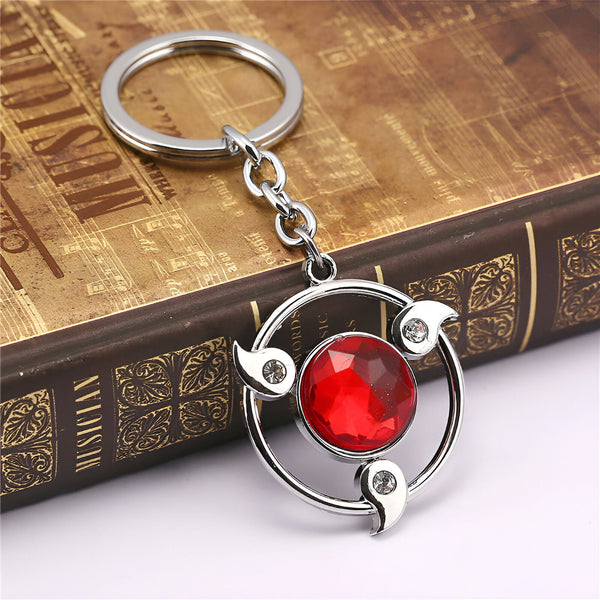 Porte-clés en métal argenté avec un symbole rouge et blanc de l'anime Naruto.