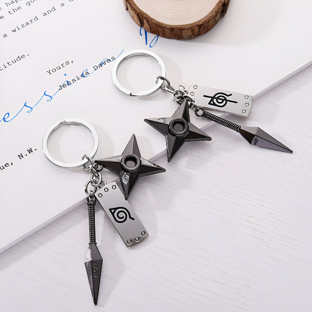 Deux porte-clés Naruto avec des shurikens, des kunais et le symbole du village caché de Konoha.