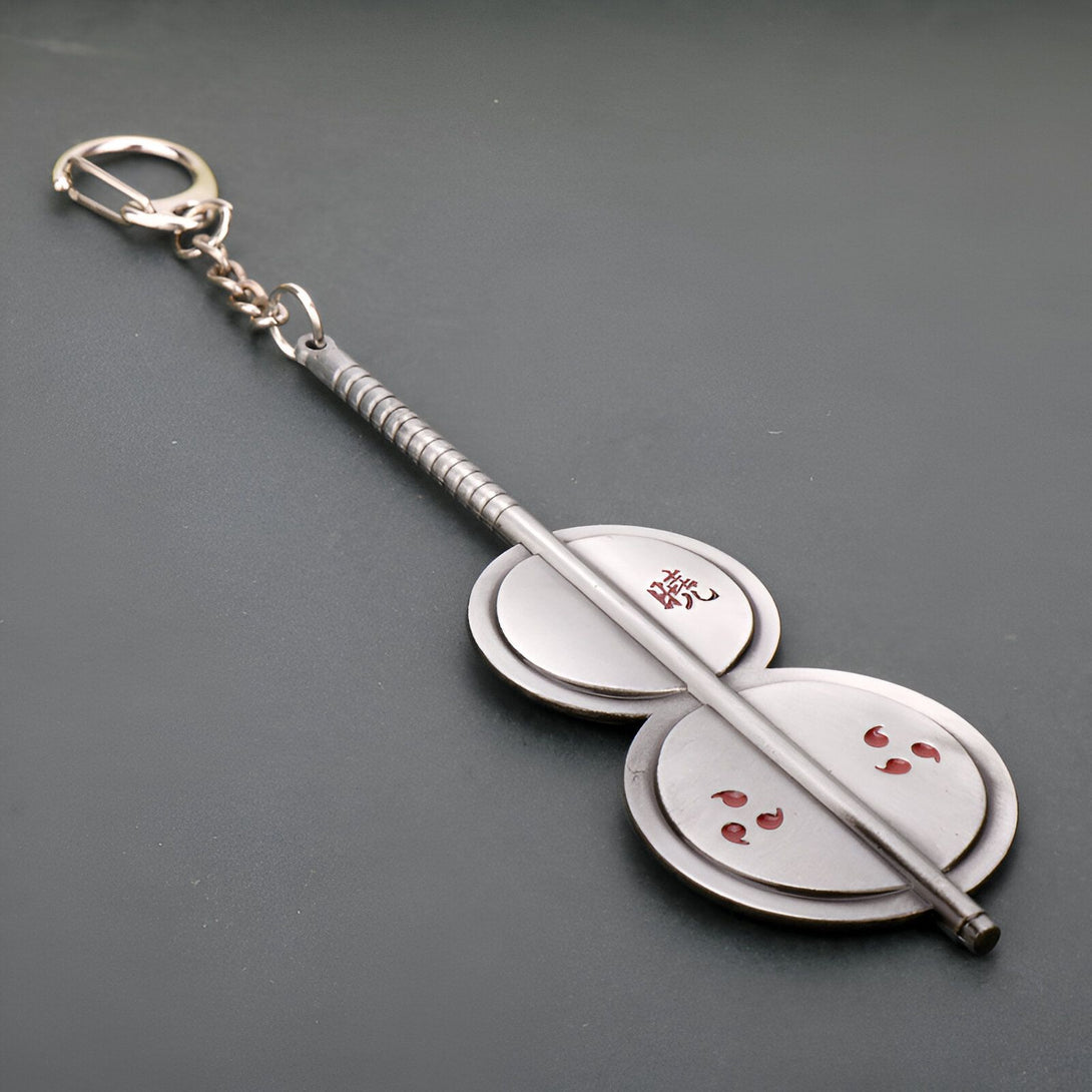 Porte-clés en métal représentant les emblèmes du clan Uchiwa de Naruto, avec le kanji "Uchiwa" gravé sur l'un des disques.