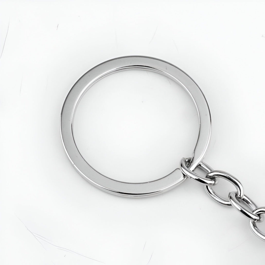 Un gros plan d'un anneau de porte-clés en métal argenté avec une chaîne attachée.