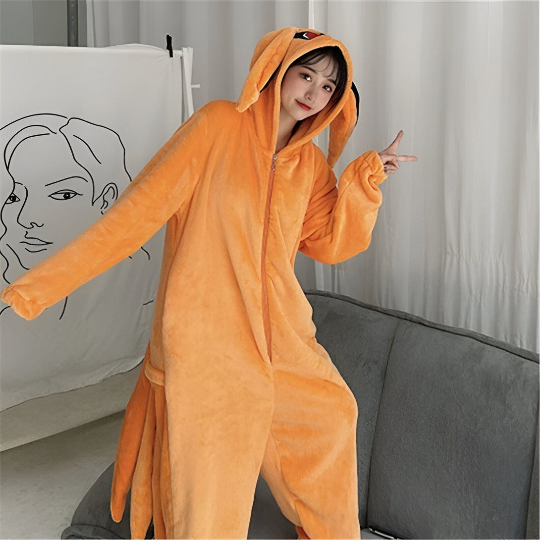 Une jeune femme porte une combinaison en fourrure orange avec des oreilles de renard. La combinaison est zippée sur le devant et elle a une capuche. La jeune femme sourit à la caméra. La combinaison est parfaite pour les fans de Naruto.