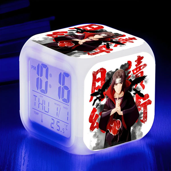 Horloge numérique blanche avec un motif de Naruto représentant le personnage de Pain en rouge et noir avec des corbeaux autour de lui. L'horloge affiche l'heure, le jour, le mois, la date et la température.