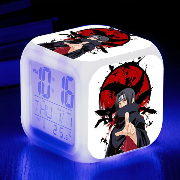 Horloge numérique blanche avec un motif de l'anime Naruto représentant le personnage de Madara Uchiha avec le Sharingan.  L'horloge affiche l'heure, le jour, le mois et la date.