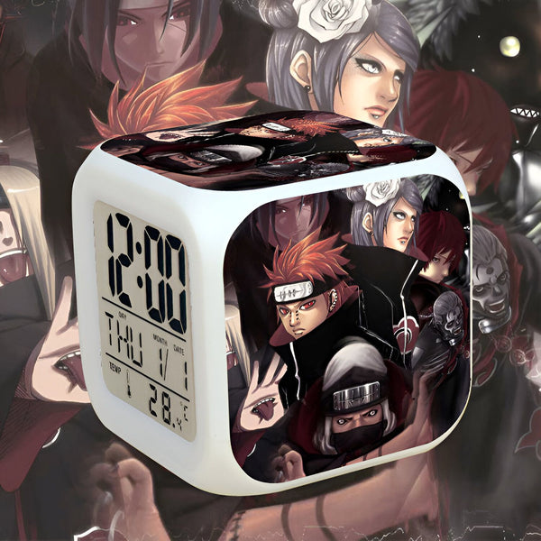 Réveil numérique blanc avec un design Naruto représentant Pain et ses six chemins. Le réveil affiche l'heure, le jour et la température.  C'est un excellent cadeau pour les fans de Naruto.